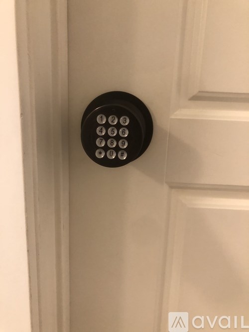 A keypad is mounted on a white door.