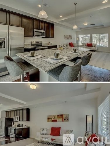 A modern kitchen and dining area with a large island and a living room with a sofa.