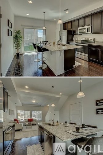 A modern kitchen with a large island and pendant lights.