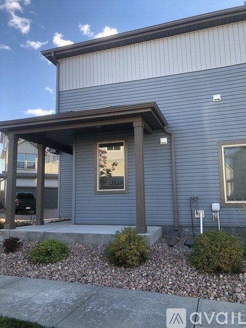 A house with a front porch and a car parked in the driveway.