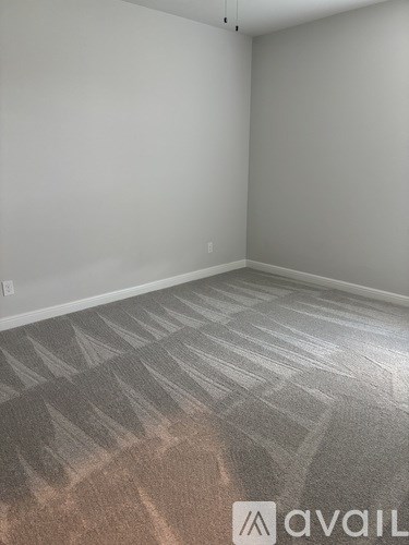 A white shelving unit in a room with carpeted floor.