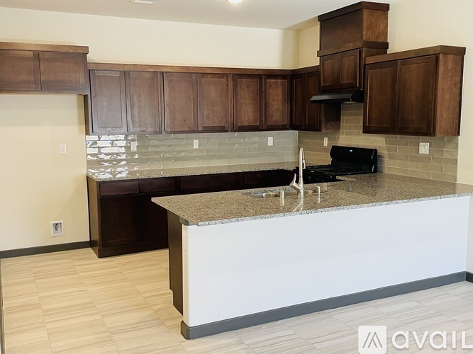 A kitchen with a granite countertop and wooden cabinets.