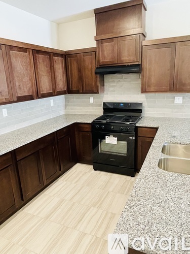 A kitchen with wooden cabinets and a black stove top oven.