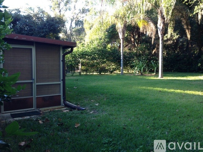 A small brown shed sits in a grassy yard.