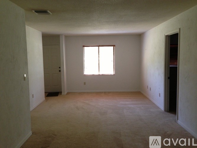 A room with a window and carpeted floor.