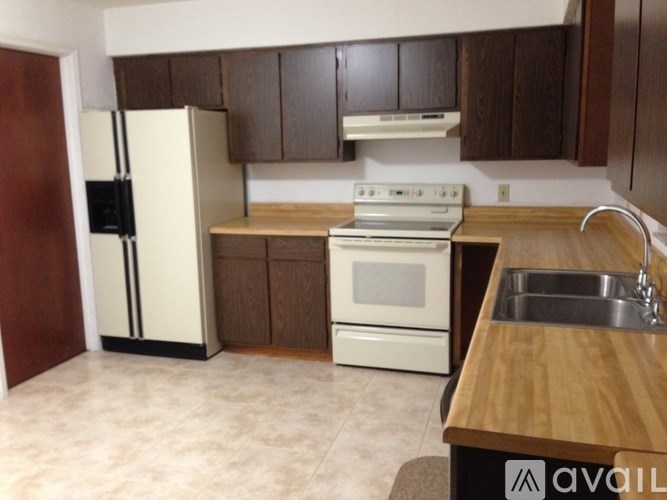 A kitchen with a white fridge and a white stove.
