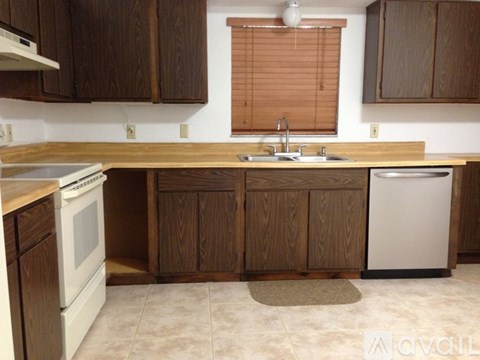 A kitchen with wooden cabinets and a white dishwasher.