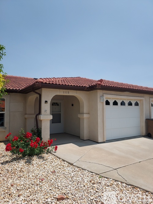 A house with a red tile roof and a white garage door.