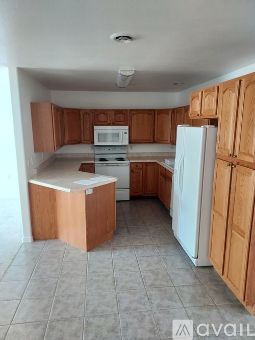A kitchen with wooden cabinets and a white refrigerator.