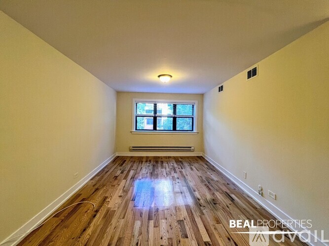 A room with wooden flooring and a window.