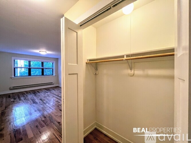 A room with a window and a wooden floor.