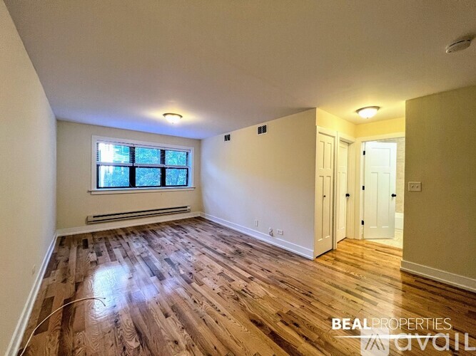 A room with wooden flooring and a window.