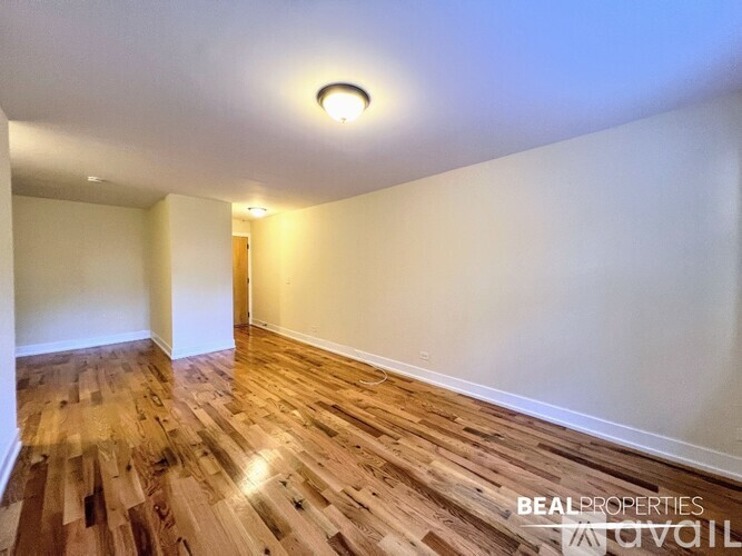 A room with wooden flooring and white walls.