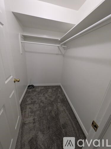 A hallway with a carpeted floor and white walls.