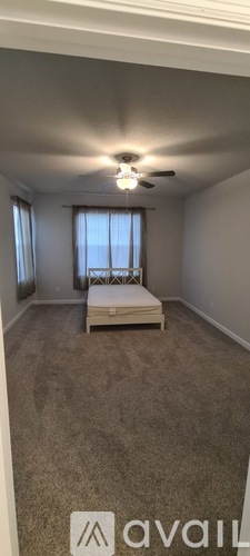 A bedroom with a bed and a window.