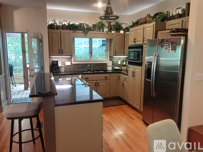 A kitchen with wooden floors and a black countertop.