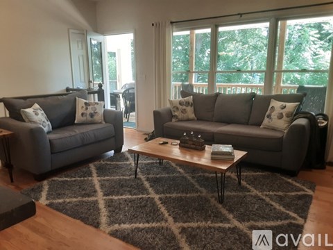 A living room with two grey couches and a coffee table.
