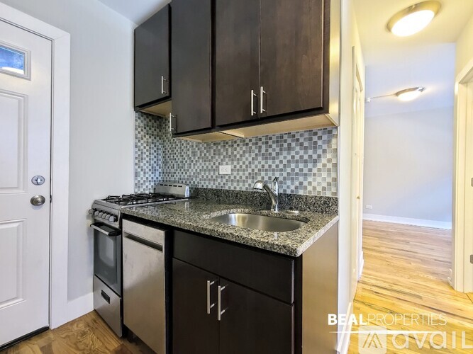A kitchen with black cabinets and a checkered backsplash.