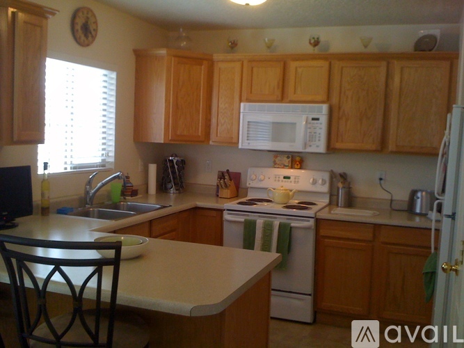 A kitchen with wooden cabinets and a white stove.