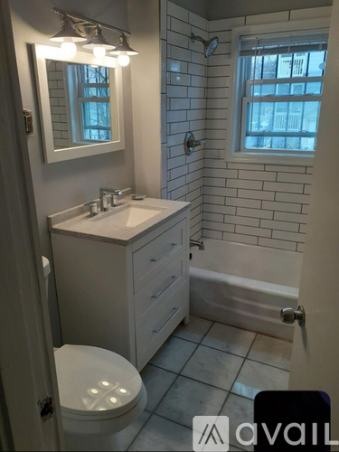 A bathroom with a toilet, sink, and tub.