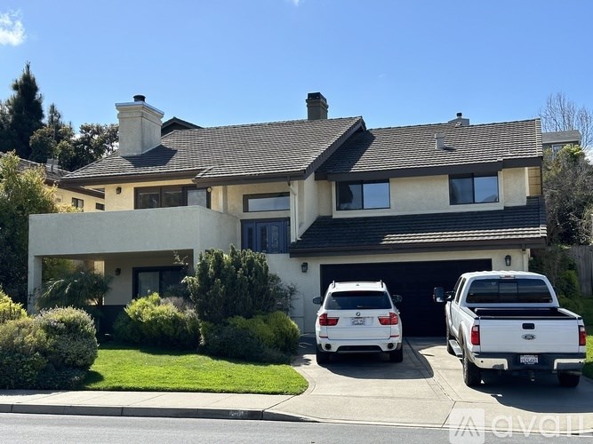 A white car is parked in front of a house.