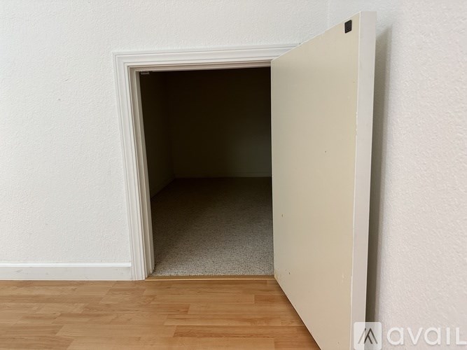 A white door is open to a small, dark room.