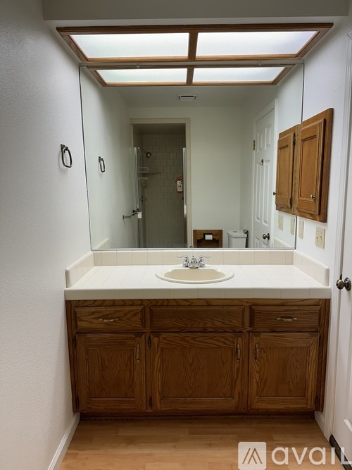 A bathroom with wooden cabinets and a white sink.
