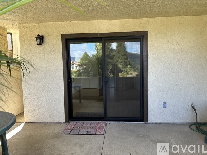 A glass door with a view of trees and houses outside.