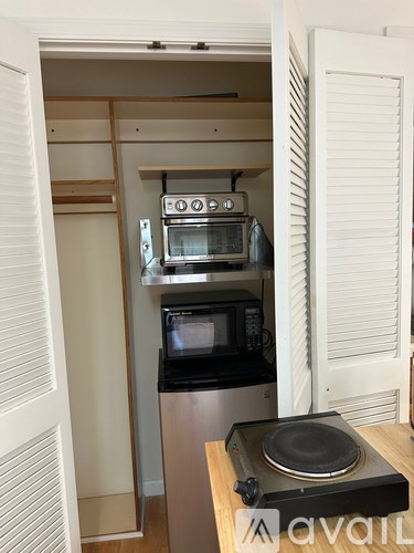 A small kitchen with a microwave and oven built into a cabinet.