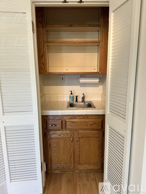 A kitchen with wooden cabinets and a white sink.