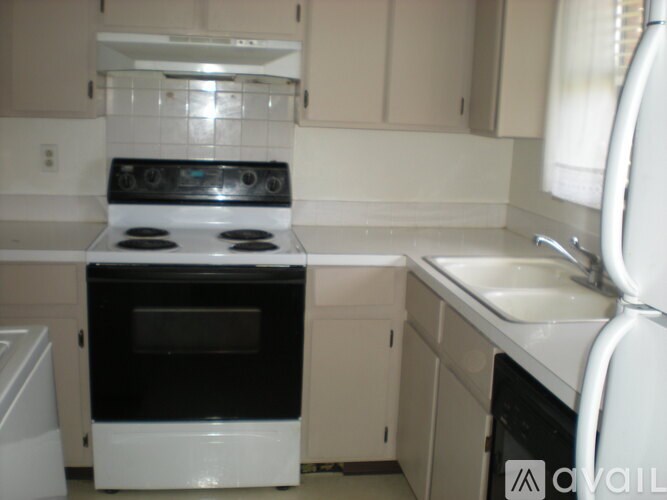 A white oven and stove top are in a kitchen.