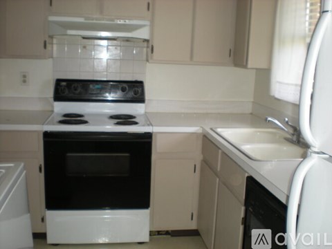 A white oven and stove top are in a kitchen.
