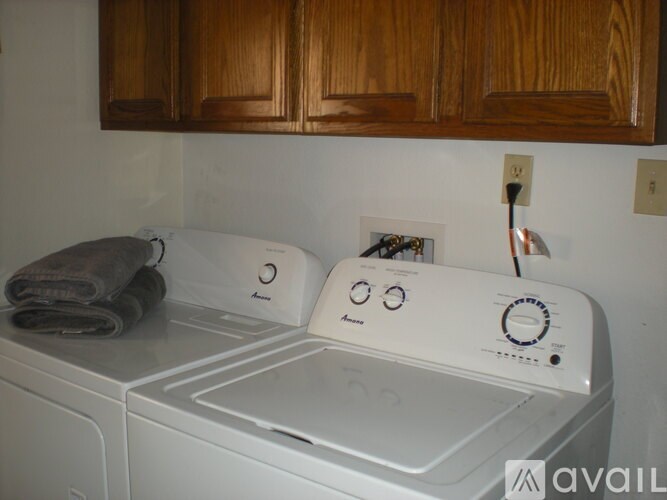 A white washing machine with a towel on top of it.