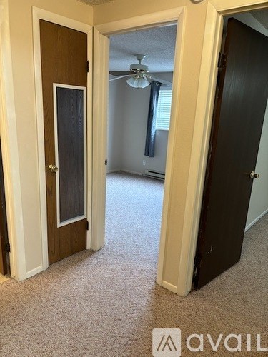 A carpeted hallway with a door on the left and a door on the right.