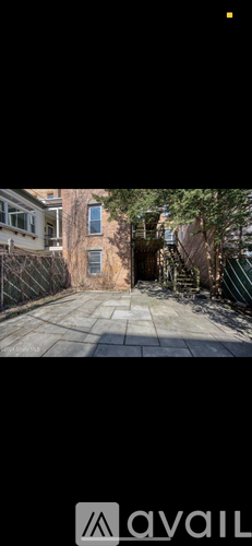A backyard with a fence and a tree.