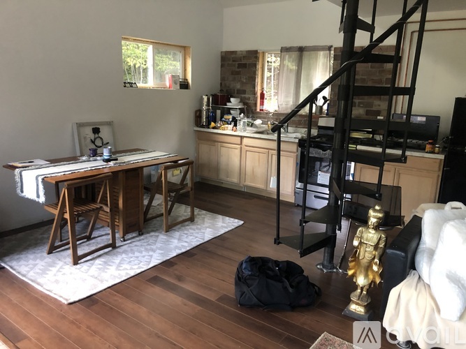 A living room with a wooden floor and a staircase.