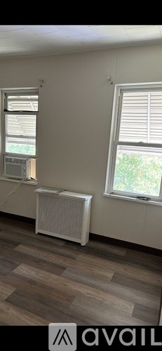 A room with a window and a radiator on the floor.