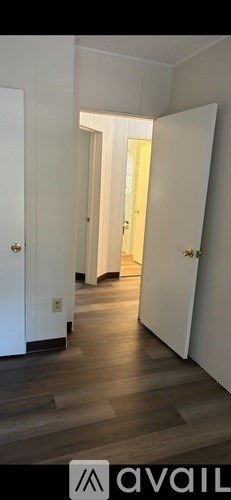 A hallway with white doors and wooden floors.