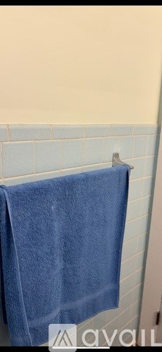 A blue towel is hanging on a towel rack.