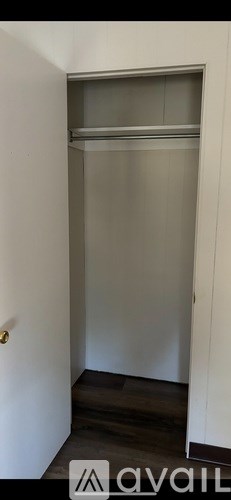 A small, empty closet with a white door and a shelf.