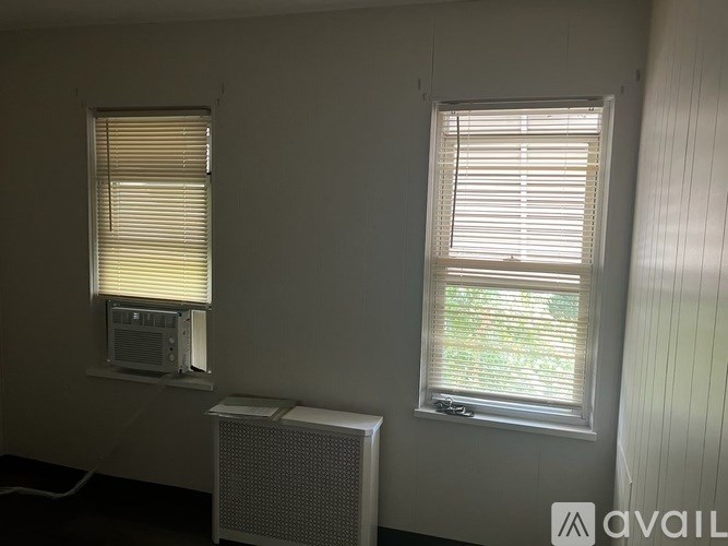 A room with a window on the right and a window on the left with a television on the left.