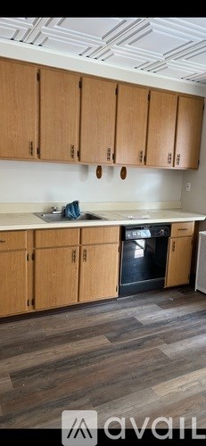 A kitchen with wooden cabinets and a black oven.