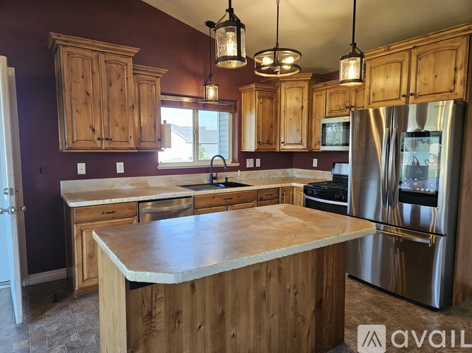 A kitchen with wooden cabinets and a marble countertop.