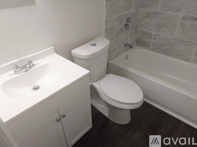 A white toilet sits next to a white sink in a bathroom.