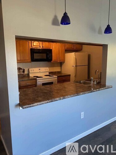 A kitchen with a white counter top and a sink.