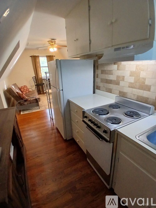 A kitchen with a stove top oven and a refrigerator.