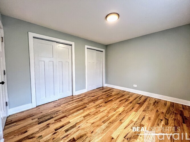 A room with wooden flooring and two doors.