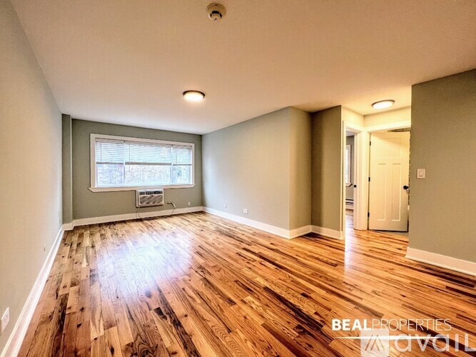 A room with wooden flooring and a window.