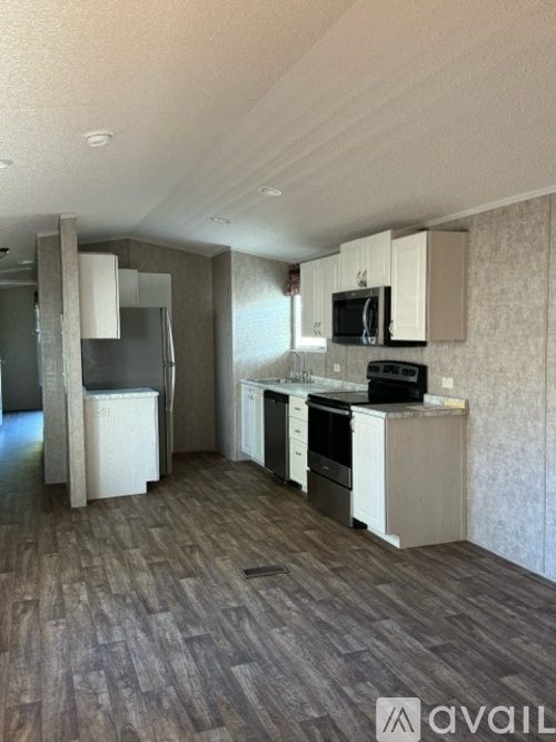 A kitchen with white cabinets and a microwave above the stove.
