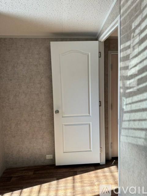 A white door is in a room with a tan wall.